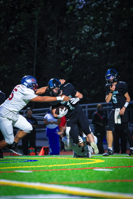 Colt Miller drives through contact near the goal line while a defender reaches to tackle him