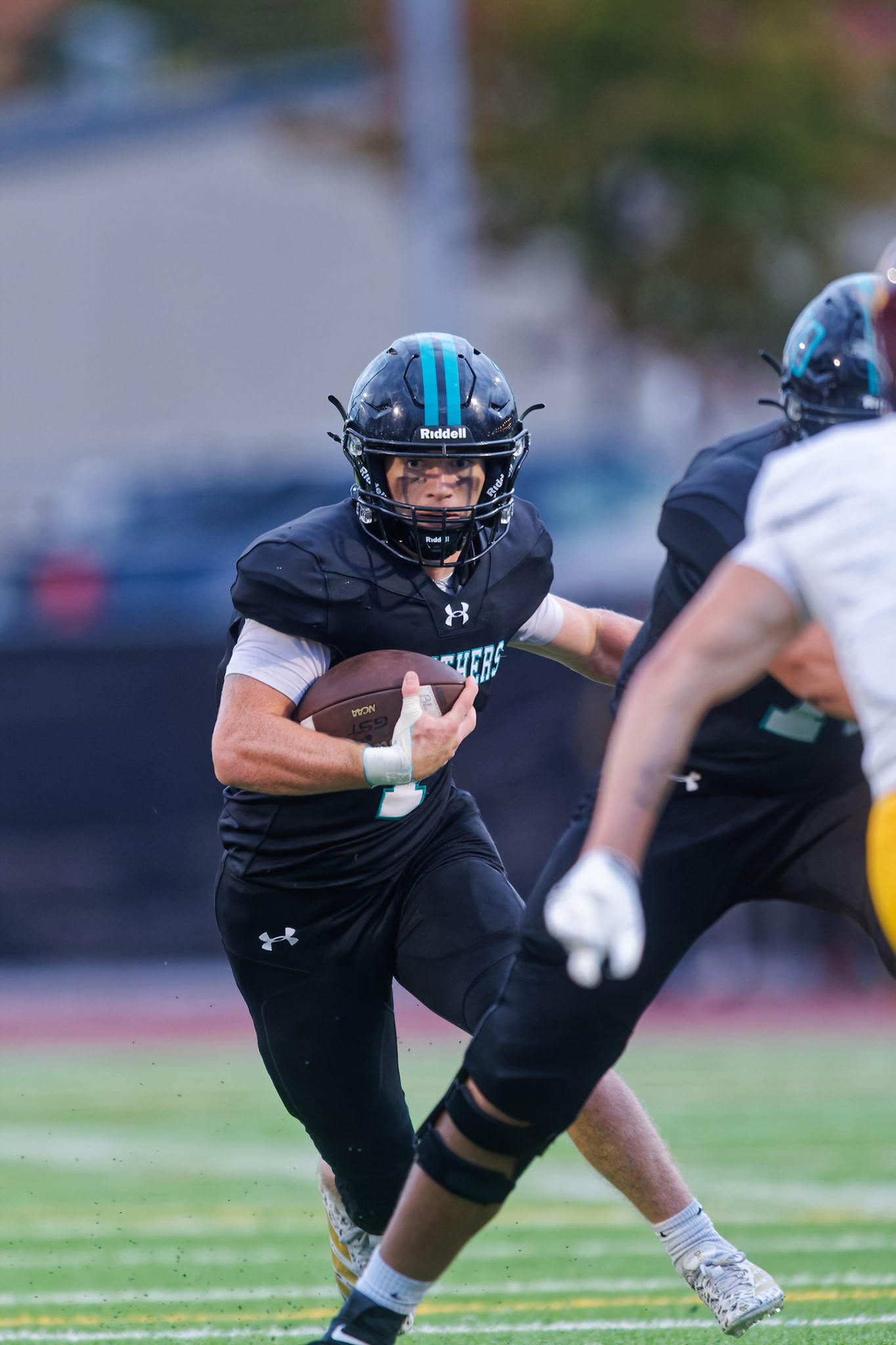Colt Miller, No. 1 for Bonney Lake, carries the football upfield in a black Panthers uniform and teal-striped helmet