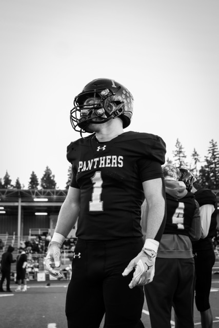 Black-and-white portrait of Colt Miller in his No. 1 Panthers jersey and helmet on the sideline